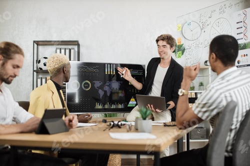 Preview: Group of four partners sitting at desk and listening speech of caucasian man near huge monitor
