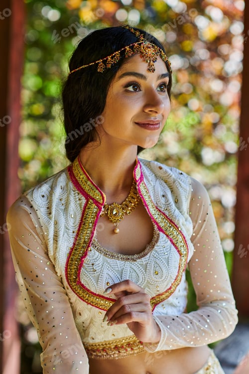 Preview: traditional fashion, portrait of young indian woman smiling and looking away in summer park