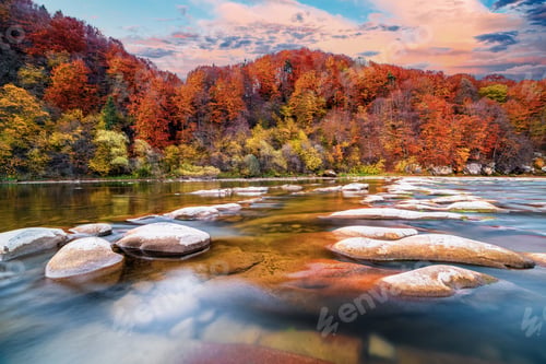 Preview: Stone bank against colorful trees growing on hills in autumn