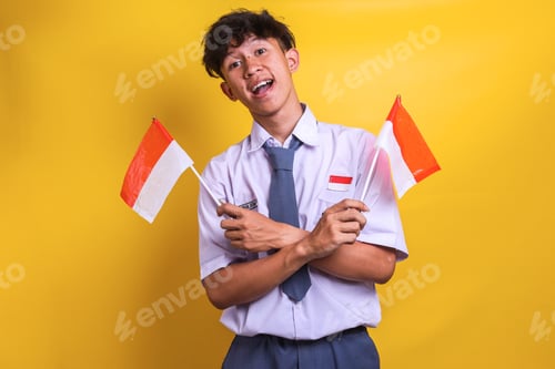Preview: Indonesian high school student man waving flags of Indonesia, celebrating the independence day.