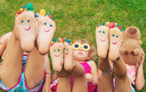 Preview: Children's feet painted on the grass. Selective focus.