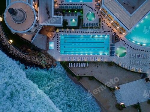 Preview: Aerial view of several pools in the spa center on a sea coast at night