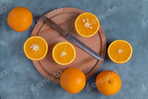 Preview: Close-up top view of ripe whole and halved oranges.