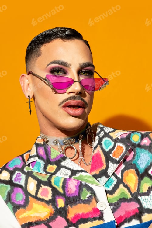 Preview: Portrait of a young drag queen in colorful dress on yellow background