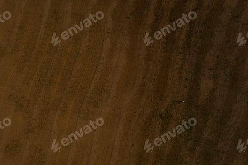 Preview: Aerial view from above. wavy field. brown earth