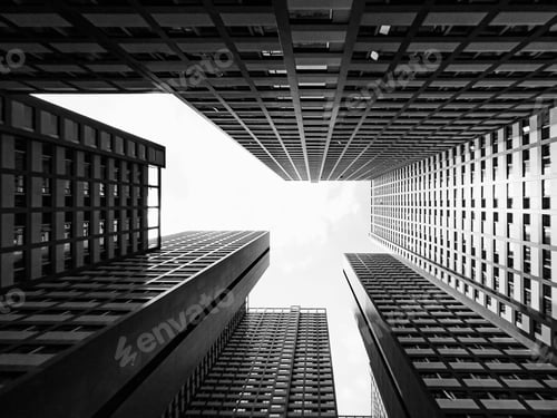 Preview: Low-angle grayscale of contemporary city buildings raising towards the bright sky