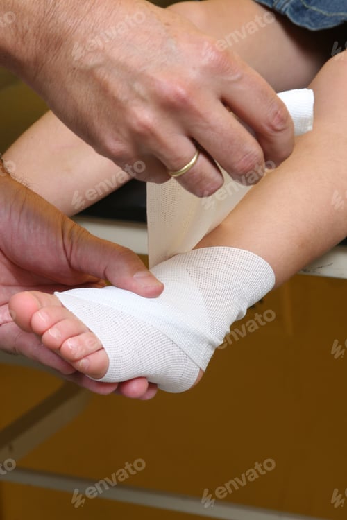 Preview: Doctor performing an ankle bandage on a girl