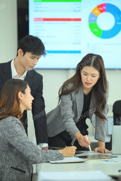 Preview: Three business professionals reviewing tablet data and reports during strategic meeting
