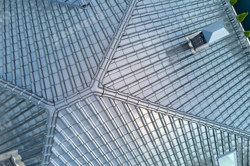 Preview: Closeup of house roof top covered with shiny ceramic shingles.
