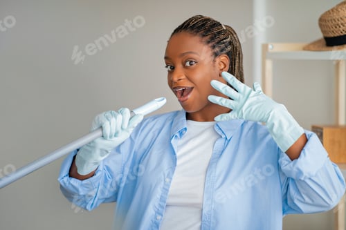 Preview: Funny young black woman singing while cleaning house