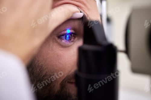 Preview: Eye exam, vision or laser test for a man with machine at optometry consultation for retina problem.