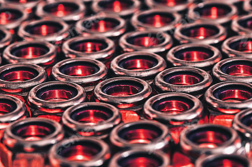 Preview: Closeup shot of endless metal screw nuts with re lights coming under it