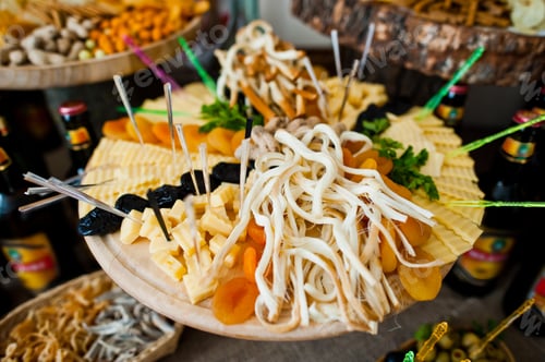 Preview: Close-up photo of sour and salty snacks on the wedding banquet along with bottles of beer.