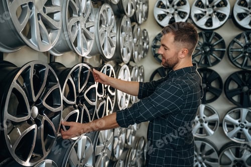Preview: Choosing the right disk. Man worker is maintenance station with tires, wheels