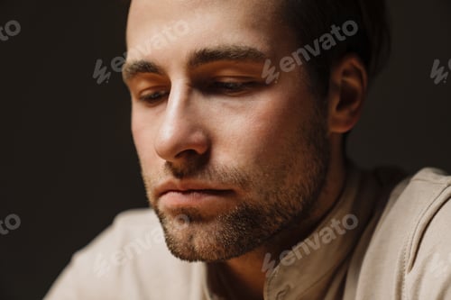 Preview: Close up of a sad upset brunette man looking down