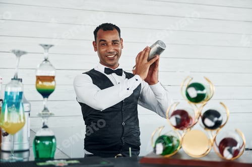 Preview: At the bar. Black waiter in formal clothes is at his work outdoors at sunny daytime