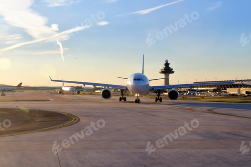 Preview: Jumbo jet airplane taxing on runway preparing to take off with airport air traffic controller tower