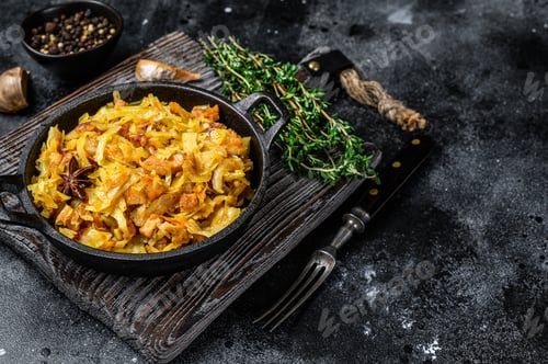 Preview: Stewed cabbage Bigos with mushrooms and sausages. Black background. Top view. Copy space