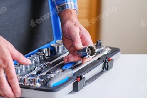 Preview: Metal Box With A Set Of Keys. A Locksmith In A Checked Shirt Holds A Key Attachment In His Hand