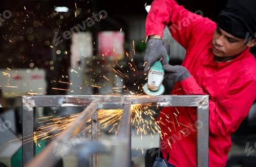 Preview: Factory worker grinding a metal,close up