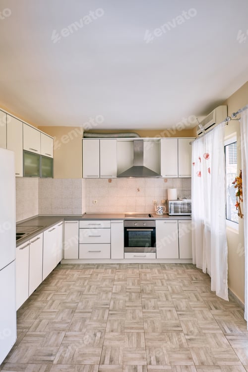 Preview: Modern kitchen with light furniture and a hood over the stove
