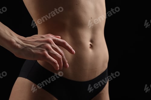 Preview: Slim woman in panties on black background, closeup