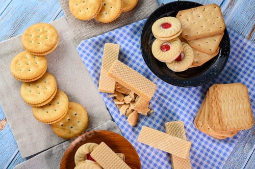Preview: Stack many types of cookies on a plate and put on a wooden table.