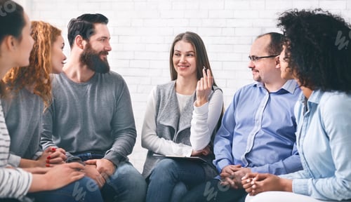 Preview: Smiling Psychologist Talking To Group Members At Therapy Session In Rehab