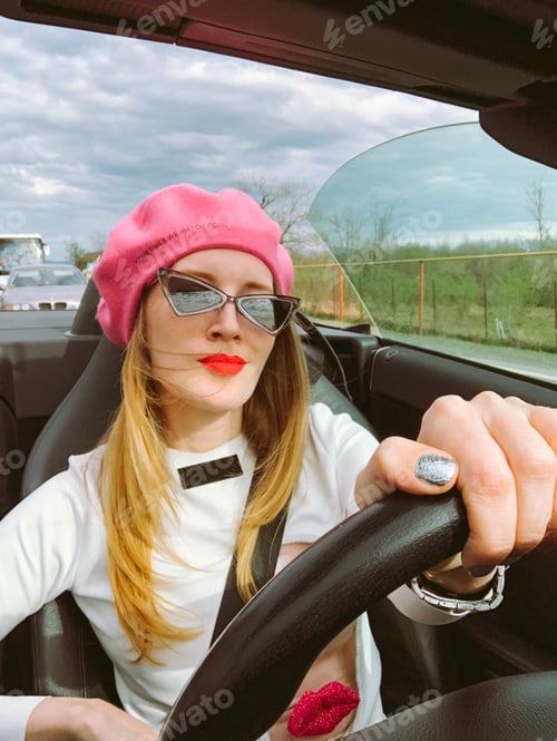 Preview: Fashionable young woman driving convertible car