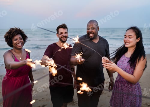 Visualização: Amigos comemorando com faíscas na praia