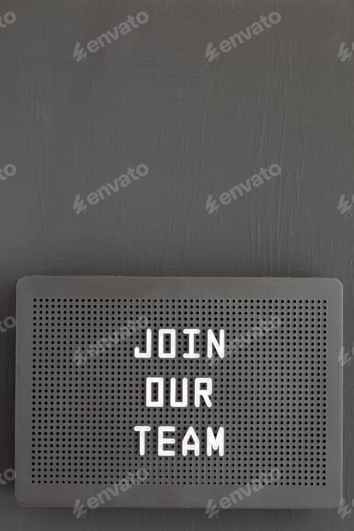 Preview: 'Join our team' words on a black lightbox on a black background, top view.