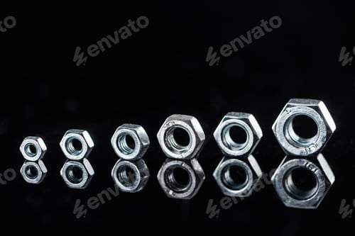 Preview: row of shiny metallic nuts isolated on black