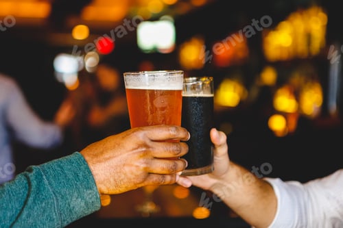 Preview: Two men's hands clinking glasses, cheers with beer, light beer and dark beer, in a restaurant bar