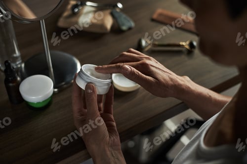 Preview: Middle Aged Caucasian Woman Applying Moisturizer Cream to Face in Bathroom
