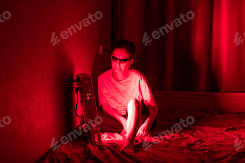 Preview: Senior woman treating sore leg with the red light therapy panel