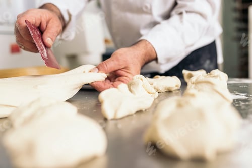 Preview: Baker kneading dough in a bakery.