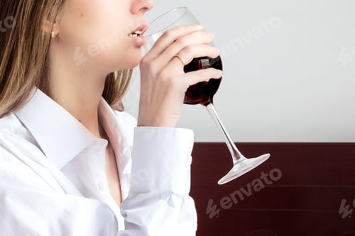 Preview: Young Caucasian woman drinking red wine at home