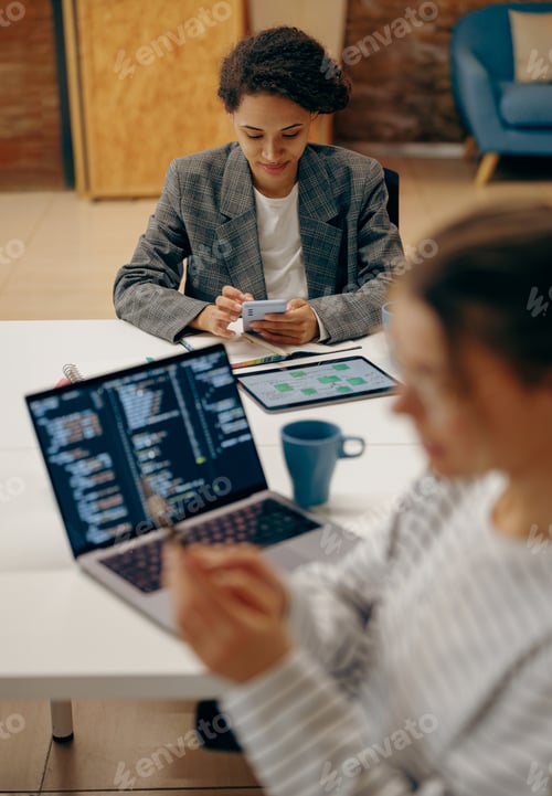 Preview: Group of female managers sitting in open office while working on digital tablet and laptop
