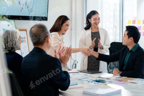 Preview: Business partners shaking hands after closing a deal in a corporate meeting