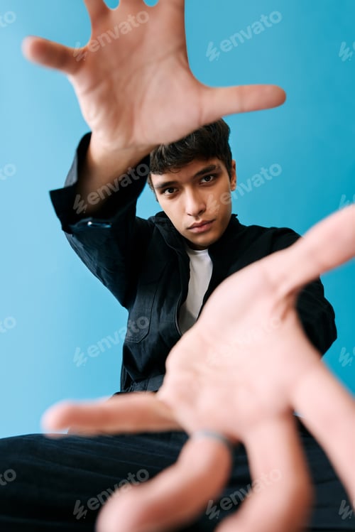 Preview: Attractive stylish young man reaching out hands to the camera