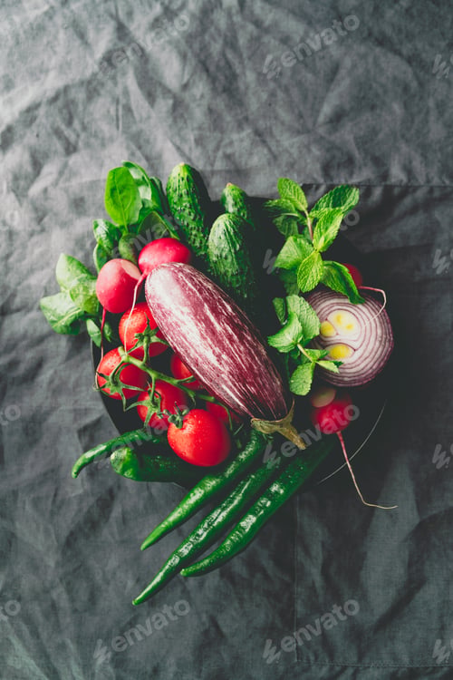 Preview: Top view of different fresh colorful vegetables in a plate on a table. Healthy eating concept.