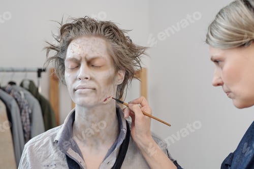 Preview: Makeup artist painting wound on face of young man
