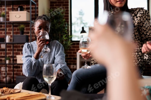 Preview: Friends gathered having wine party at home in living room while celebrating birthday event