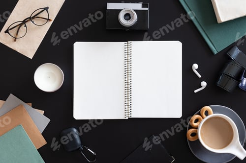 Preview: Open blank notebook on black background, flat lay.