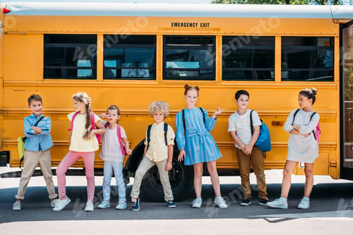 Preview: group of happy pupils posing in front of school bus