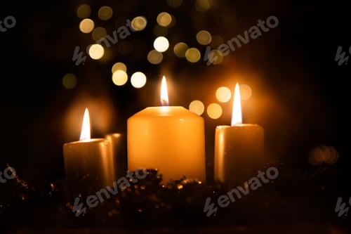 Preview: Closeup of candles burning brightly in a dark room