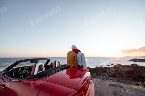 Preview: Lovely couple on the beach near the car on a sunset