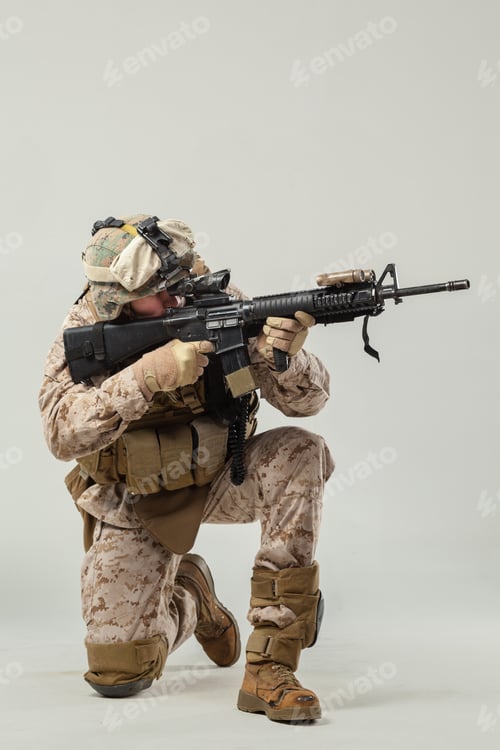 Preview: Soldier kneels while aiming rifle during training exercise indoors at military facility