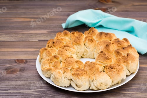 Preview: Homemade monkey bread on a plate and napkin on a wooden table