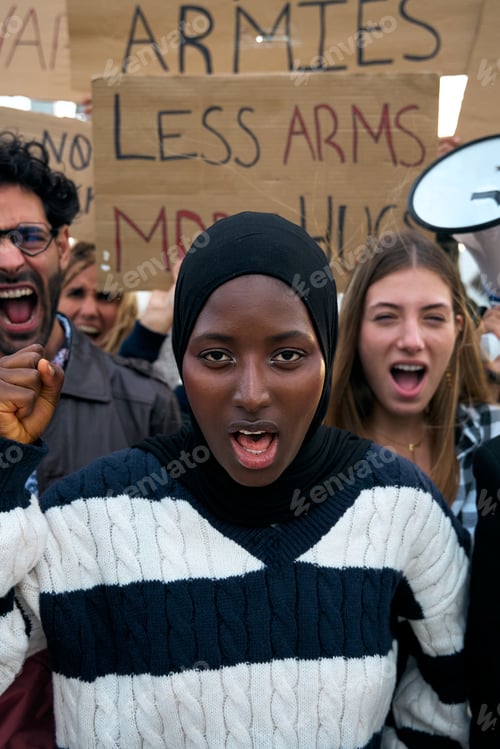 Preview: Vertical. Young Muslim woman with crowd of people protesting against war and violence